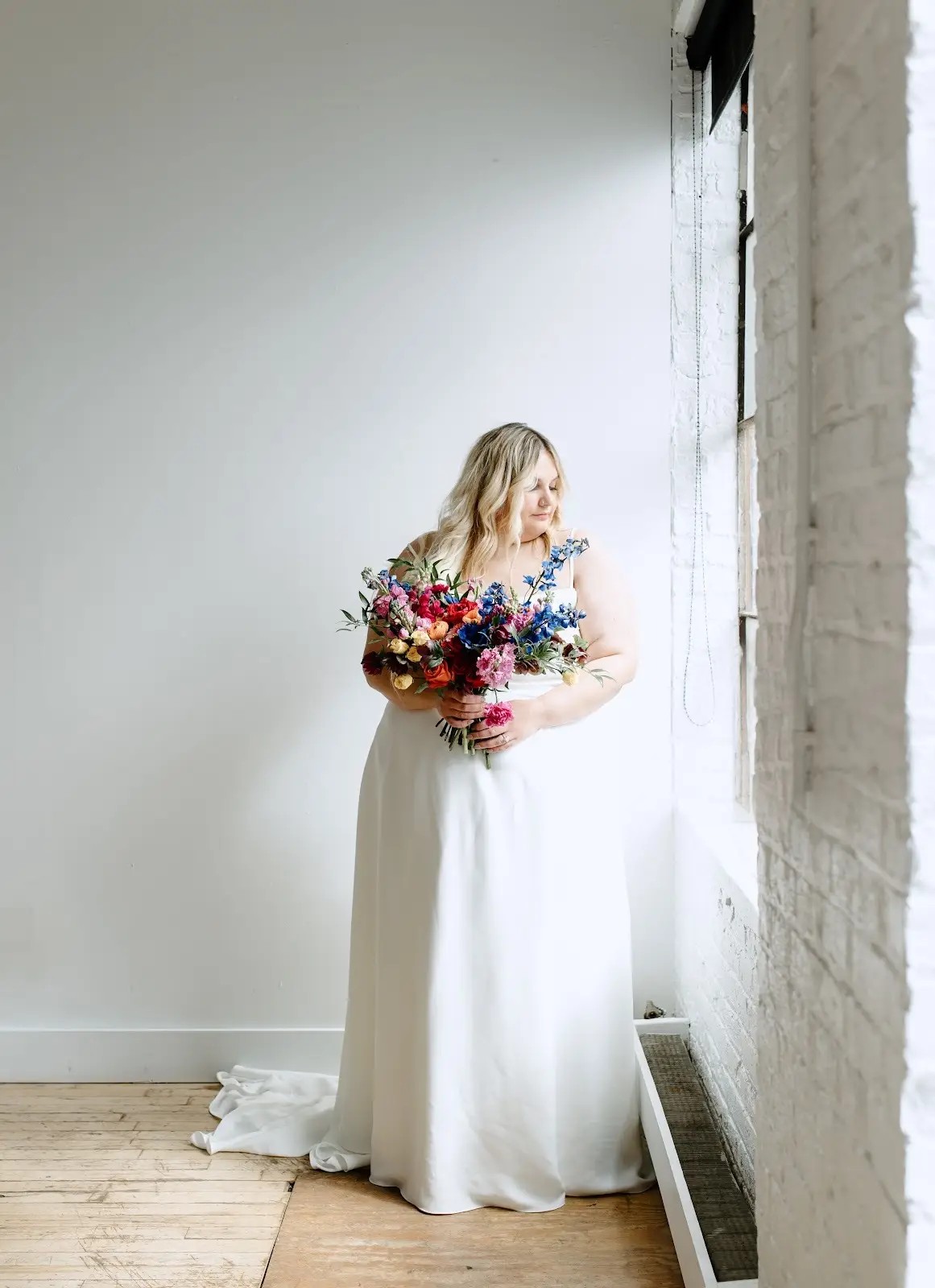 model wearing a wedding gown and holding a bouquette